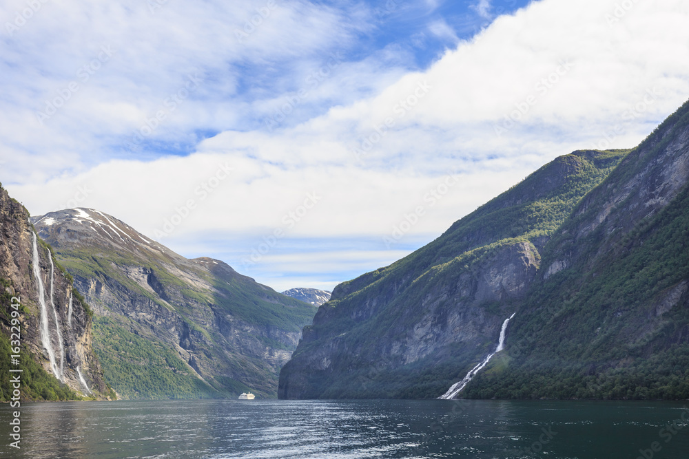 Two most notable waterfalls in Geiranger Fjord - Seven Sisters Falls (on left) and Suitor (or  Friar). Both falls face one another across fjord, and Suitor is said to be trying to woo sisters opposite