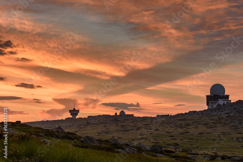 First rays of the summer sun  under dark stormy clouds - beautiful sunrise on a mountain top - July morning at Black Peak  Vitosha  Sofia  Bulgaria