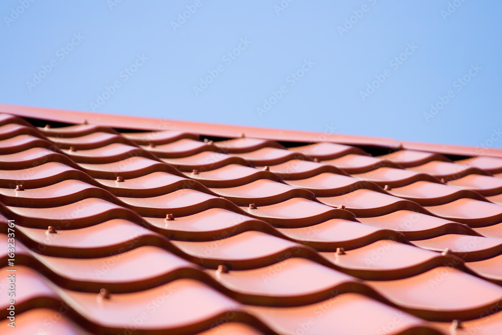 Red roof of metal roofing on the sky background Red roof of metal roofing on the sky background