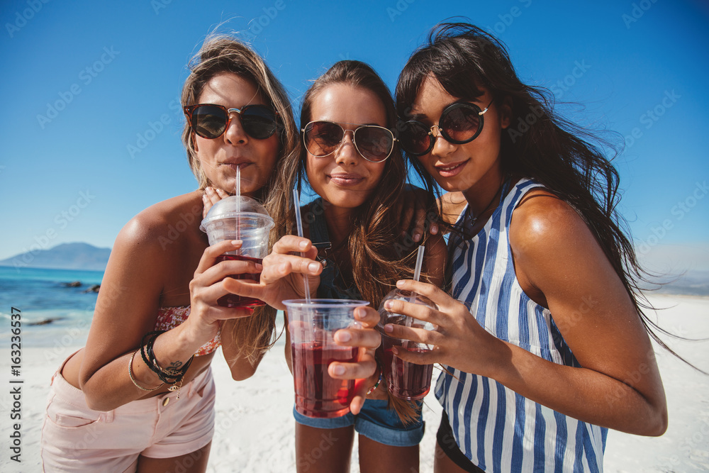 Girlfriends drinking ice tea on the beach Girlfriends drinking ice tea on the beach