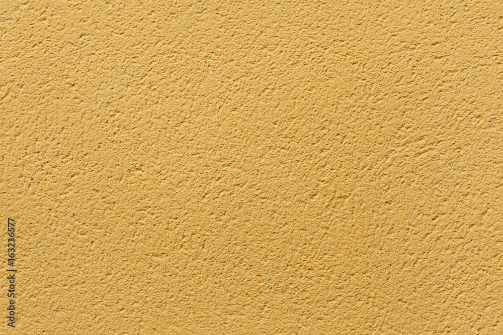 Yellow ochre painted stucco wall. Background texture.