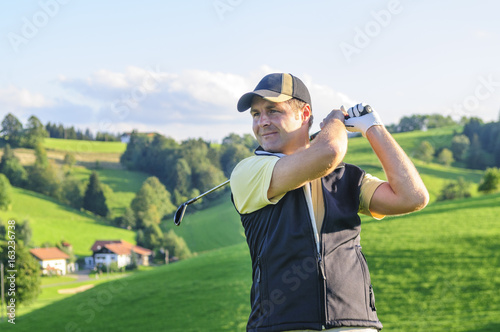 Golfspieler schaut seinem Abschlag hinterher