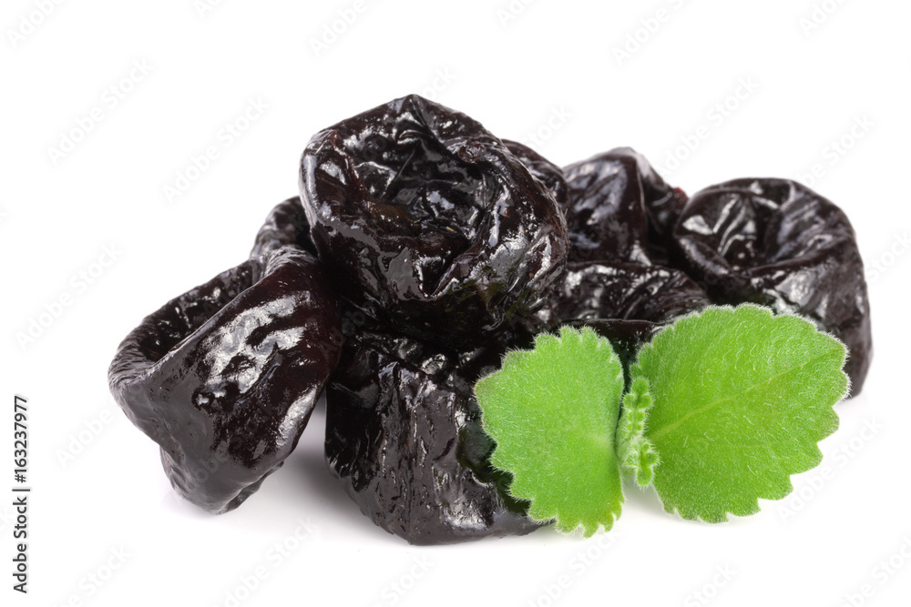 heap of dried plums or prunes with a mint leaf isolated on white background heap of dried plums or prunes with a mint leaf isolated on white background