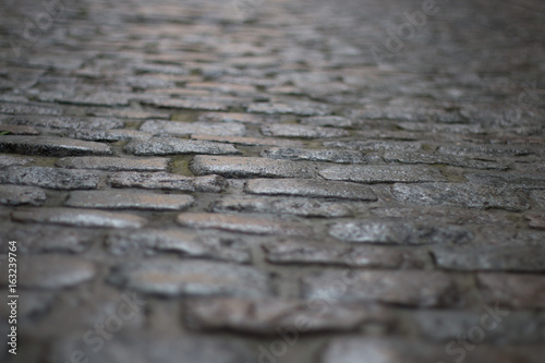 Dark cobblestones shot from the ground with very direct and dramatic light, shot in brussels in belgium