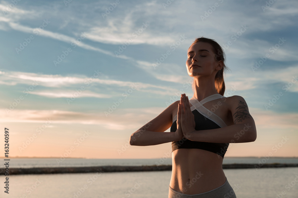 Fototapeta premium Sports lady at the beach make meditate exercises.