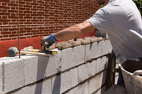 Obrero construyendo un muro de bloques de hormigón 1. © Lola Fdez. Nogales