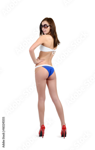 Young girl in bikini and sunglasses posing on white background