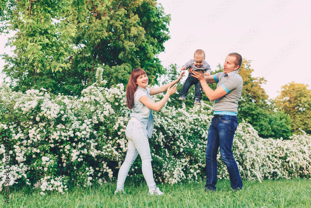Fototapeta premium Happy male and female playing with children outside