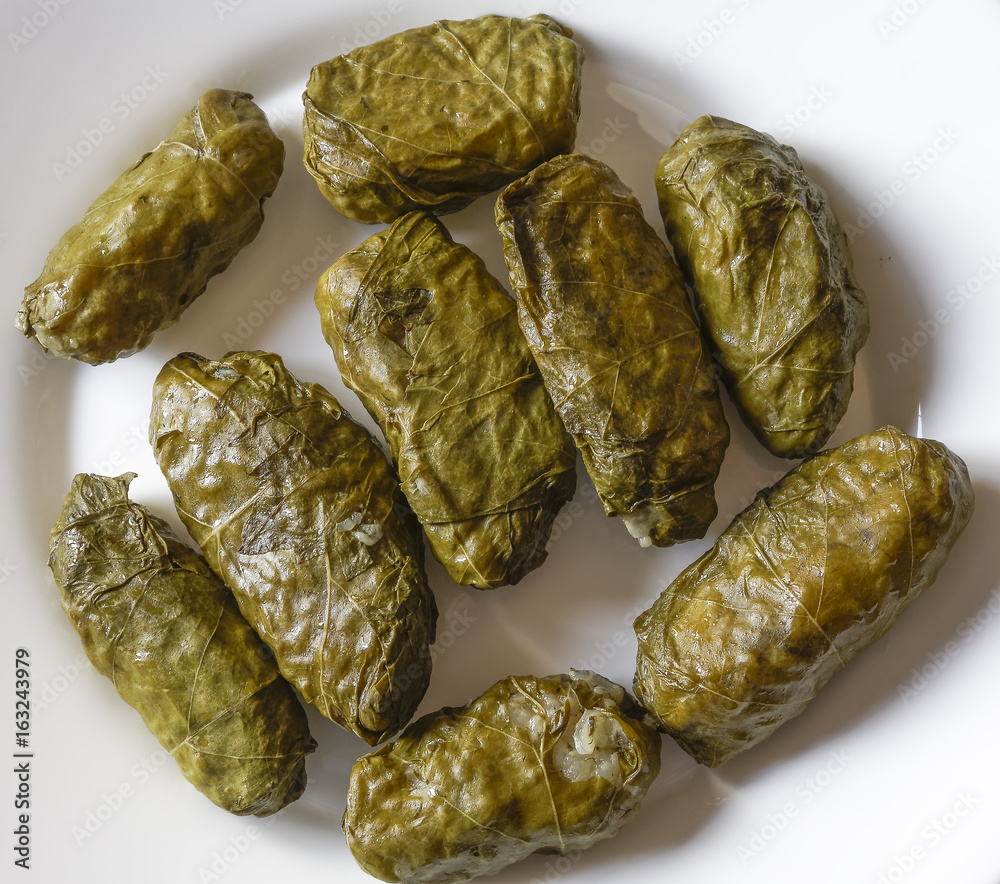 Grape leaves stuffed with rise closeup top view.
Fresh grape leaves, called dolmadakia in Greece, served in a white dish. Grape leaves stuffed with rise closeup top view.
Fresh grape leaves, called dolmadakia in Greece, served in a white dish.