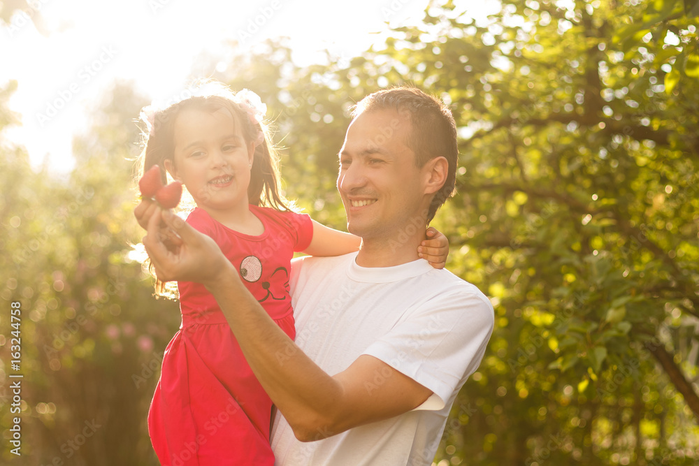Happy smiling young father and daughter playing in the park Happy smiling young father and daughter playing in the park