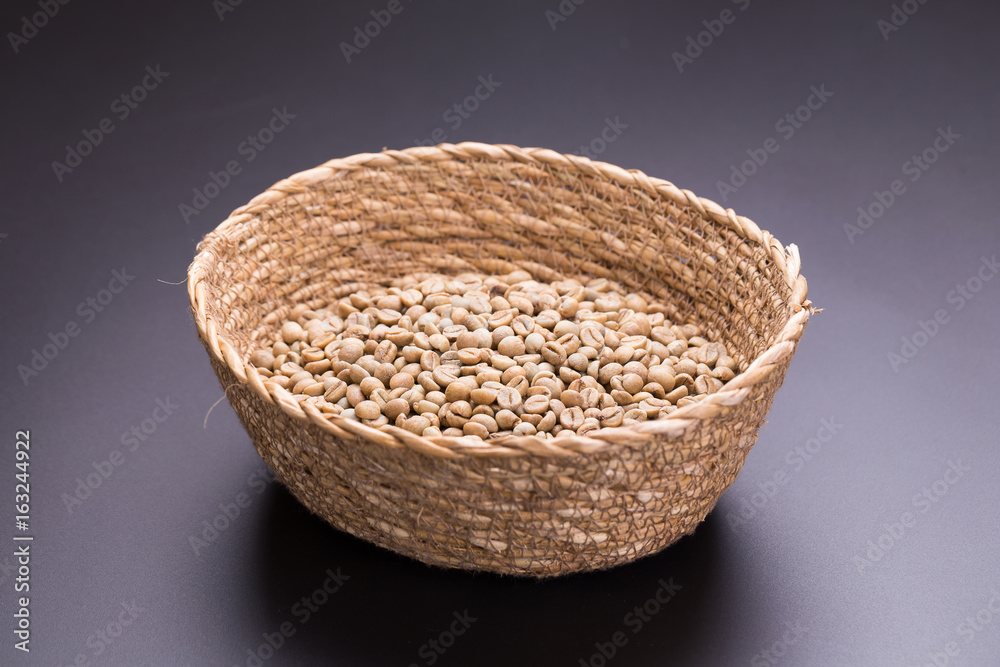 Unroasted coffee bean In the basket on black background