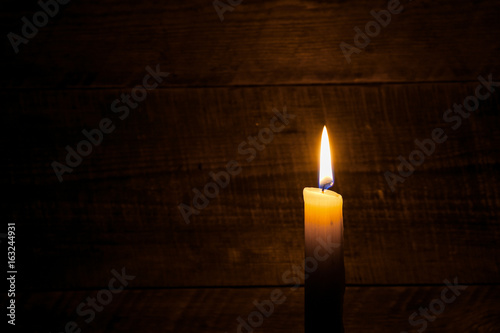 beeswax candle on old wooden background