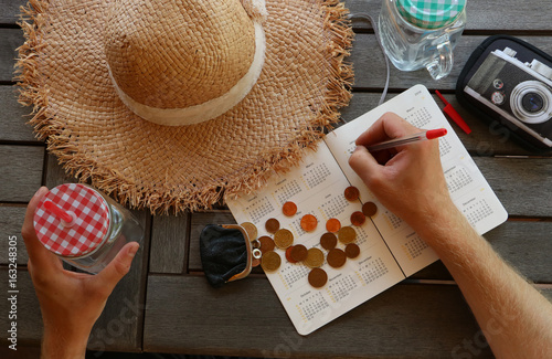 Man is planing travel budget and drinking summer drink photo