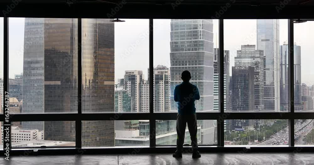 4k,a businessman Overlooking the urban business building from window,skyscrapers,economic center. 4k,a businessman Overlooking the urban business building from window,skyscrapers,economic center.