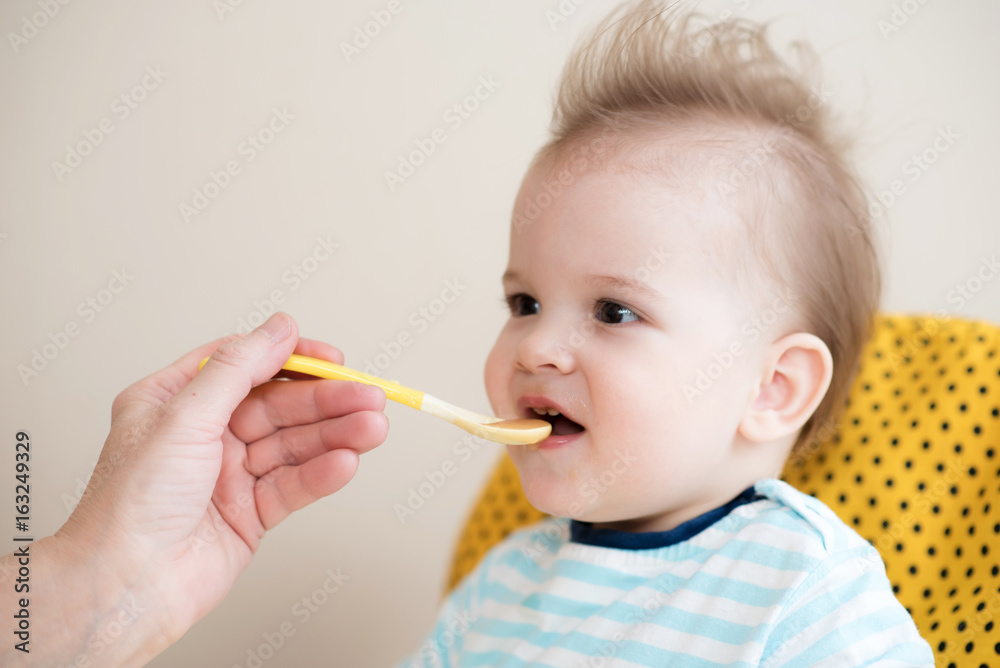 grandmother gives baby food from a spoon grandmother gives baby food from a spoon