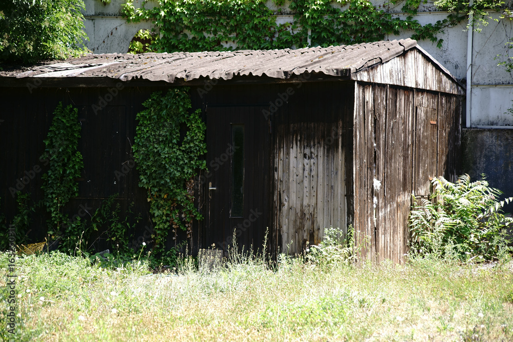Holzhütte / Eine alte Holzhütte aus abgenutzten Bretterwänden dient als Unterstand für Werkzeuge. Holzhütte / Eine alte Holzhütte aus abgenutzten Bretterwänden dient als Unterstand für Werkzeuge.