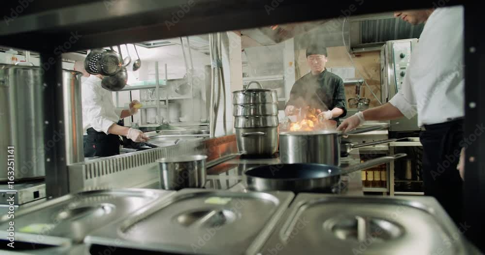 the workflow in the kitchen of the restaurant,a team of Asian chefs prepare dishes the workflow in the kitchen of the restaurant,a team of Asian chefs prepare dishes