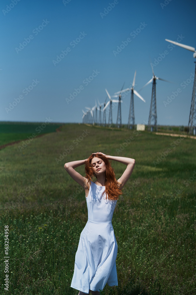 © SHOTPRIME STUDIO - Beautiful young woman in a field near a windmill, summer, sun