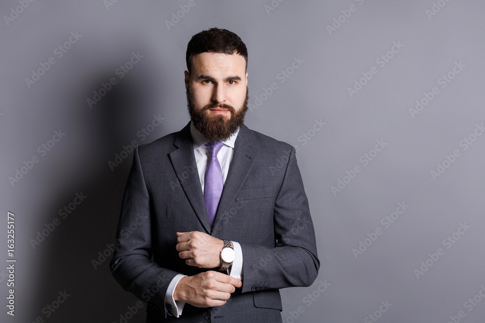 Bearded man in suit adjusting sleeves copy space Bearded man in suit adjusting sleeves copy space