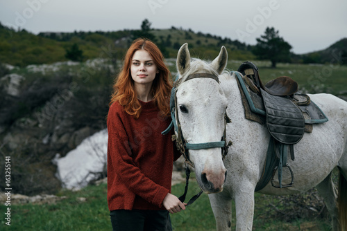 1122441 Beautiful young woman in the mountains walking with her horse, nature