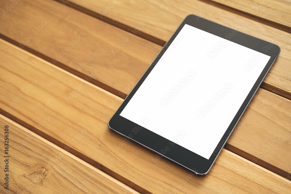 Mockup image of black tablet pc with blank white screen on vintage wooden table background Mockup image of black tablet pc with blank white screen on vintage wooden table background