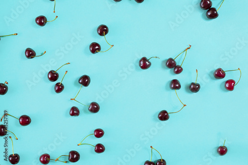 Fresh juicy cherries on mint background, top view photo