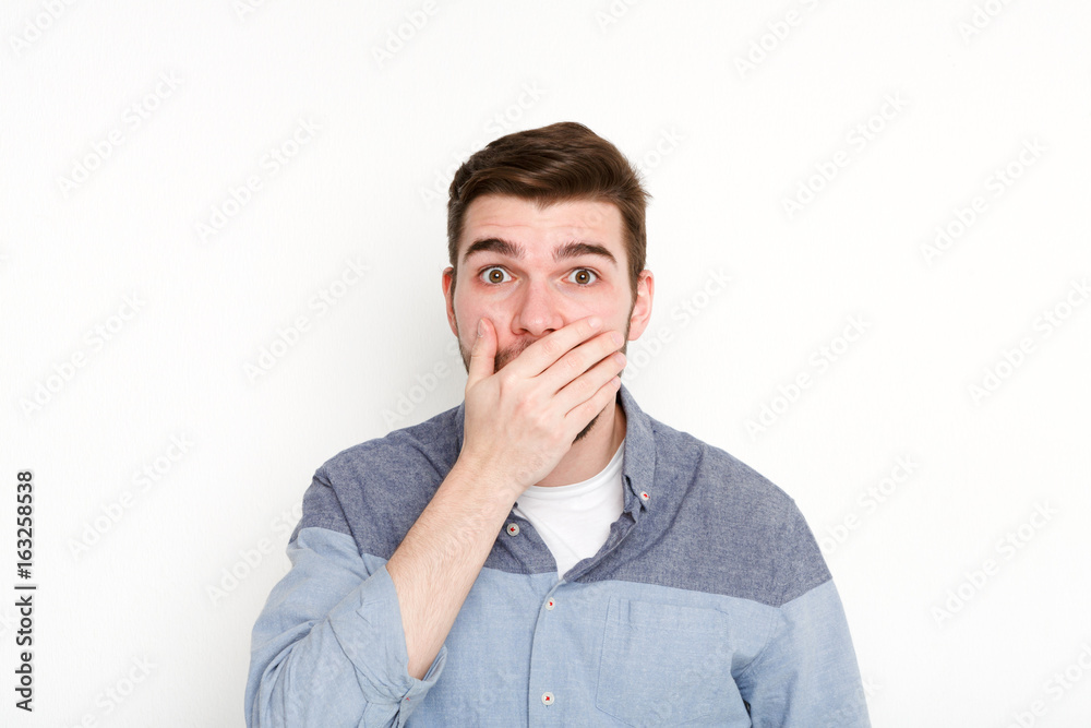 Surprised man covering mouth with hand