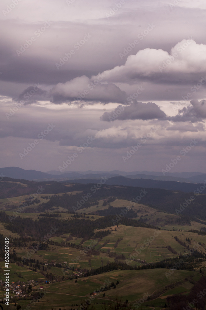 Beautiful mountain landscape, with mountain peaks covered with forest and a cloudy sky. Carpathian mountains, Europe