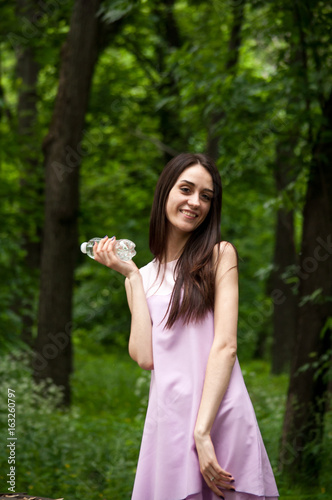 Young smiling woman with bottle of water  outdoors