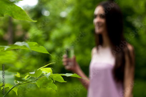 Portrait of young woman drinking water, outdoor, with copyspace