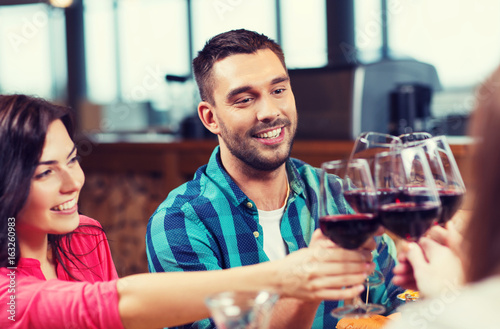 friends clinking glasses of wine at restaurant