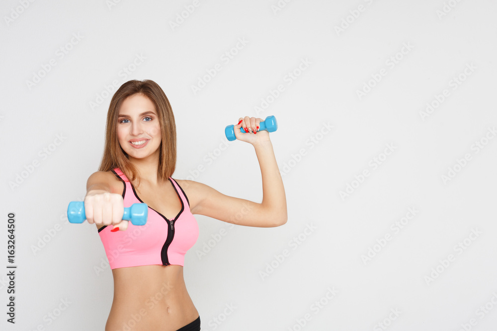Fitness model woman with dumbbells on white Fitness model woman with dumbbells on white