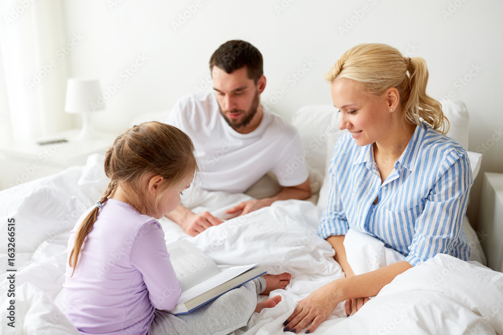 happy family reading book in bed at home happy family reading book in bed at home