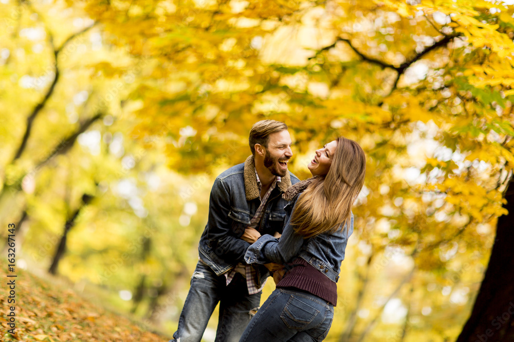 Smiling couple hugging in autumn park and having fun Smiling couple hugging in autumn park and having fun