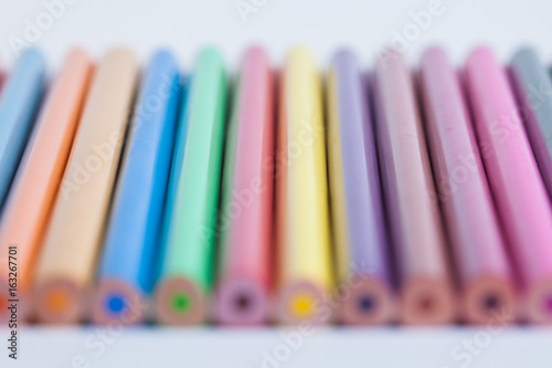 Colored pencils in a blurred form. The image is blurred. A set of colored pencils out of focus