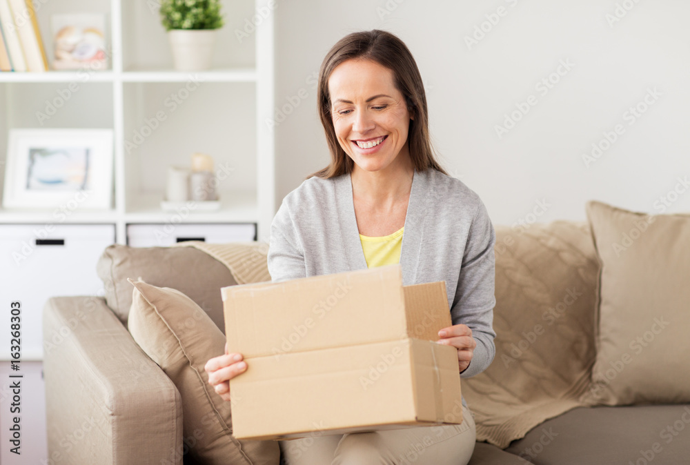 smiling woman opening cardboard box smiling woman opening cardboard box