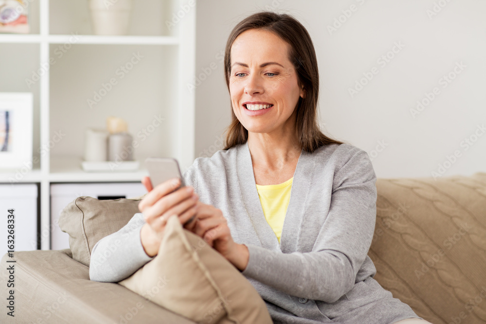 happy woman texting message on smartphone at home happy woman texting message on smartphone at home