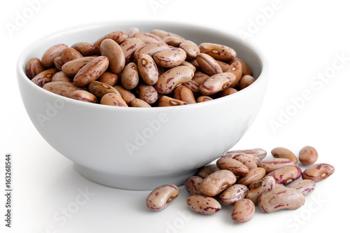 Fotografie Dry pinto beans in white ceramic bowl isolated on white