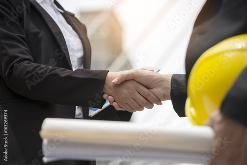 Business people Handshake (shaking hands) with partnership in city,Two business man,woman,architecture greeting,successful after signing contract.Negotiation,signing,contract,handshake concept 