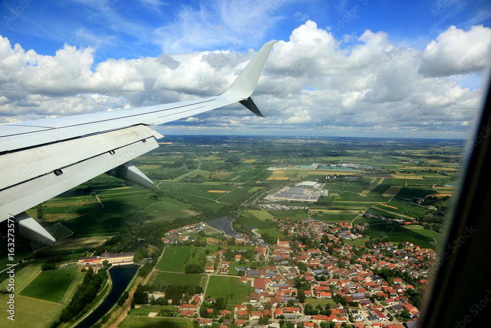 Widok miasta i pól z okna lecącego samolotu. - obrazy, fototapety, plakaty 