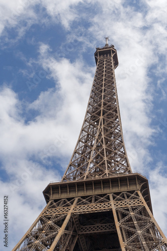 Eiffel tower in Paris against blue sky with white clouds