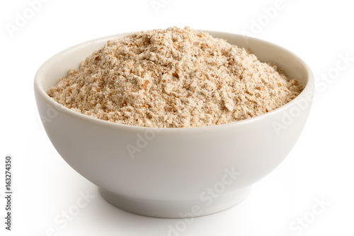Spelt whole grain flour in white ceramic dish isolated on white.