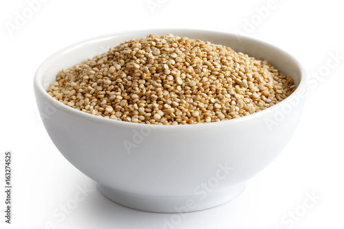 Quinoa seeds in white ceramic dish isolated on white.