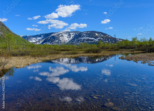 View of the Hibiny  Khibiny  Mountains with a reflection in the water of a small river. Kirovsk  Kola Peninsula  Murmansk region  Russia.