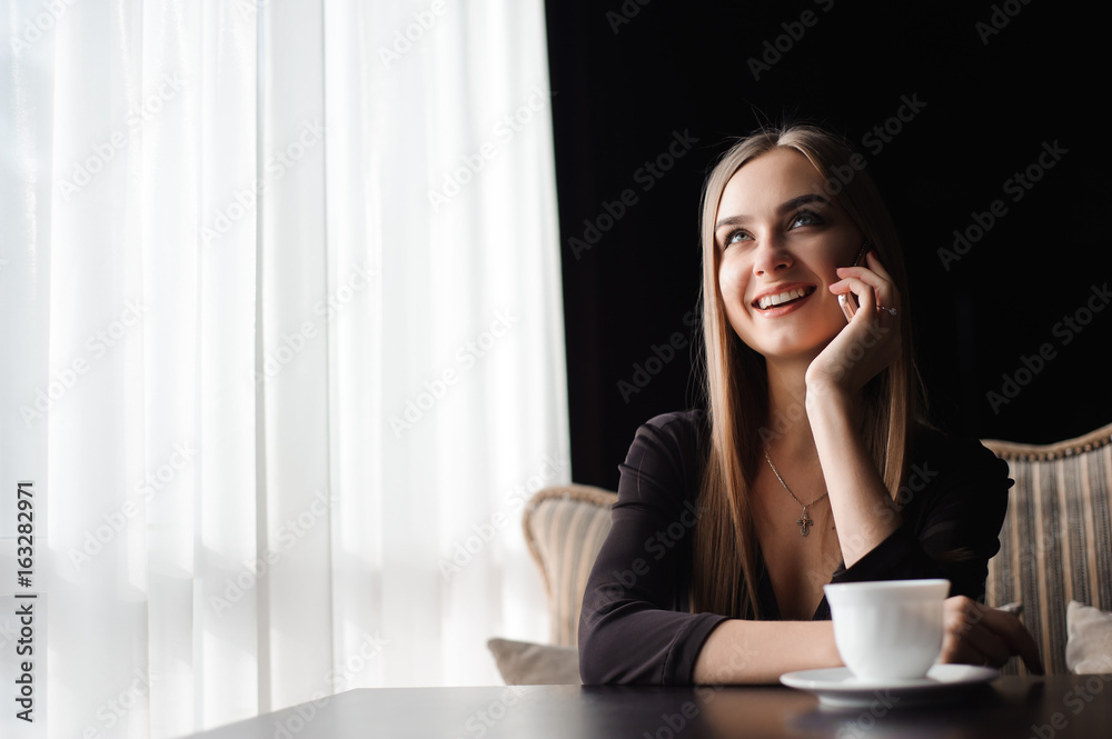 attractive female with cute smile having talking conversation with mobile phone while rest in cafe attractive female with cute smile having talking conversation with mobile phone while rest in cafe