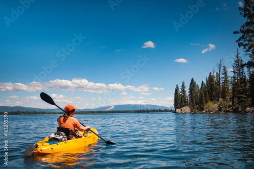 Woman kayaking on Lake Jenny in Grand Tetons National Park photo