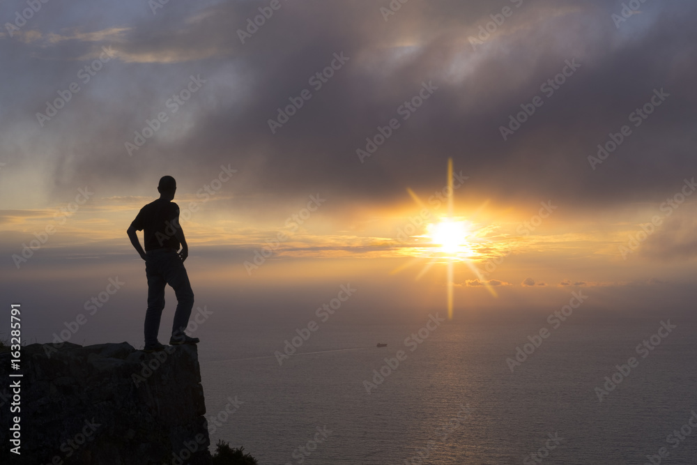 Man doing sport on top of mountain at sunset