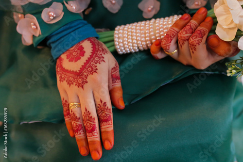 female hand, image of mehendi henna pattern. Short manicure nails. Beautiful composition, fabric background banner. Round mandala abstract flowers, flowers lilac. Close up professional art photo photo