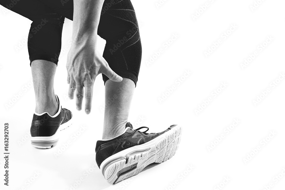 Runner sportsman holding ankle in pain with Broken twisted joint running sport injury and Athletic man touching foot due to sprain on white background Runner sportsman holding ankle in pain with Broken twisted joint running sport injury and Athletic man touching foot due to sprain on white background