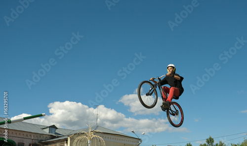 Young man jumping and riding on a BMX bicycle
